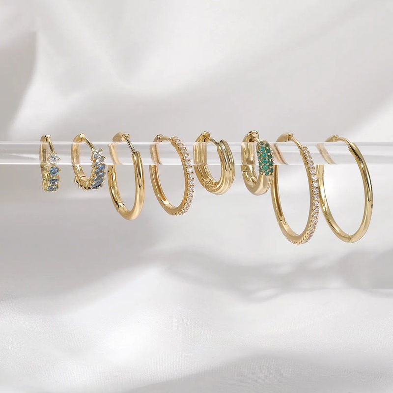 A row of gold-tone hoops in several sizes on a display stand, showing the size range