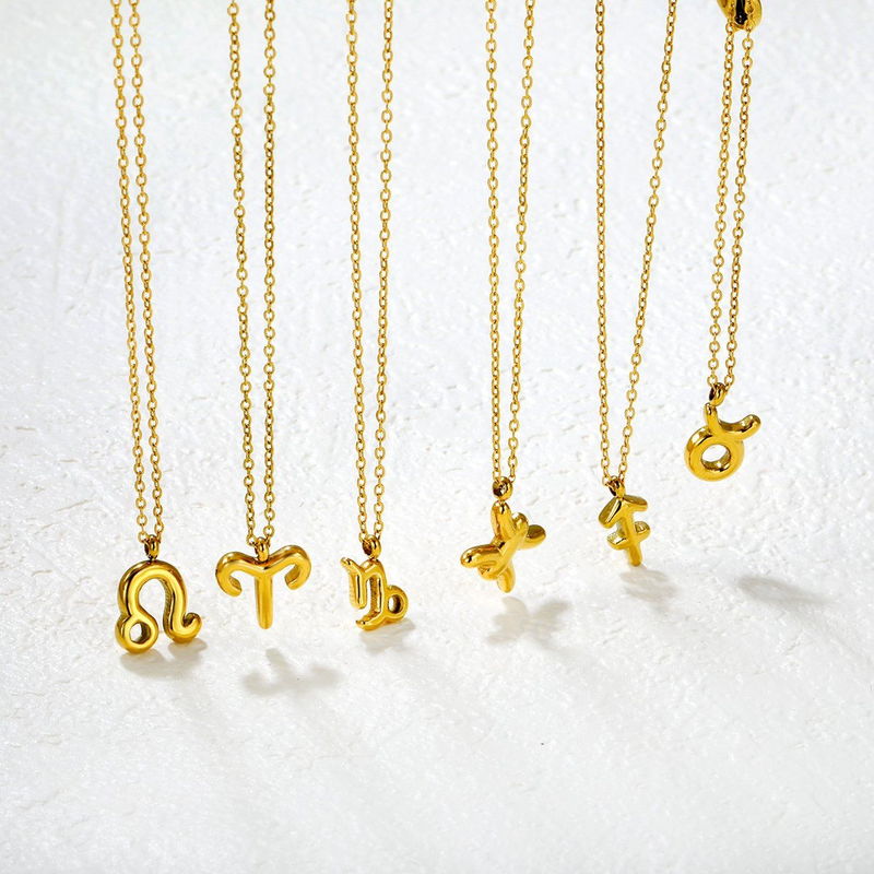 Six small gold-tone pendant necklaces on fine chains hanging side by side
